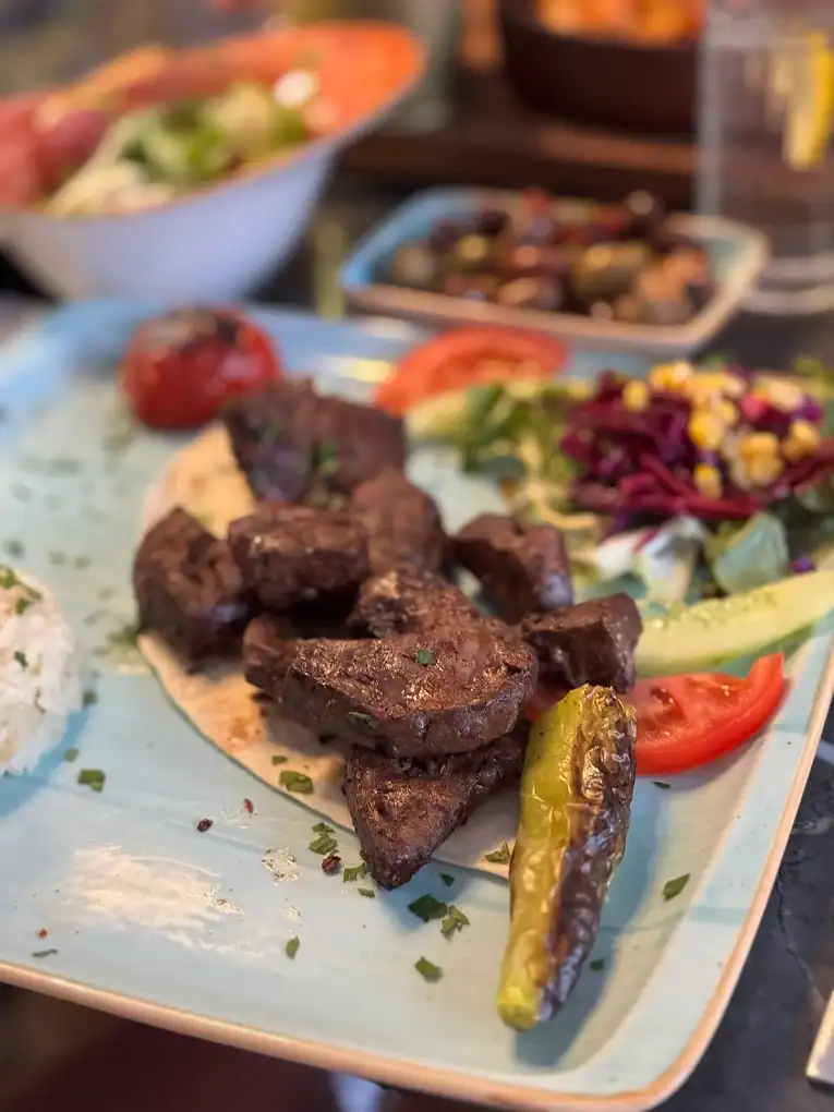 Delicious grilled meat with fresh vegetables and peppers at a recommended local restaurant.