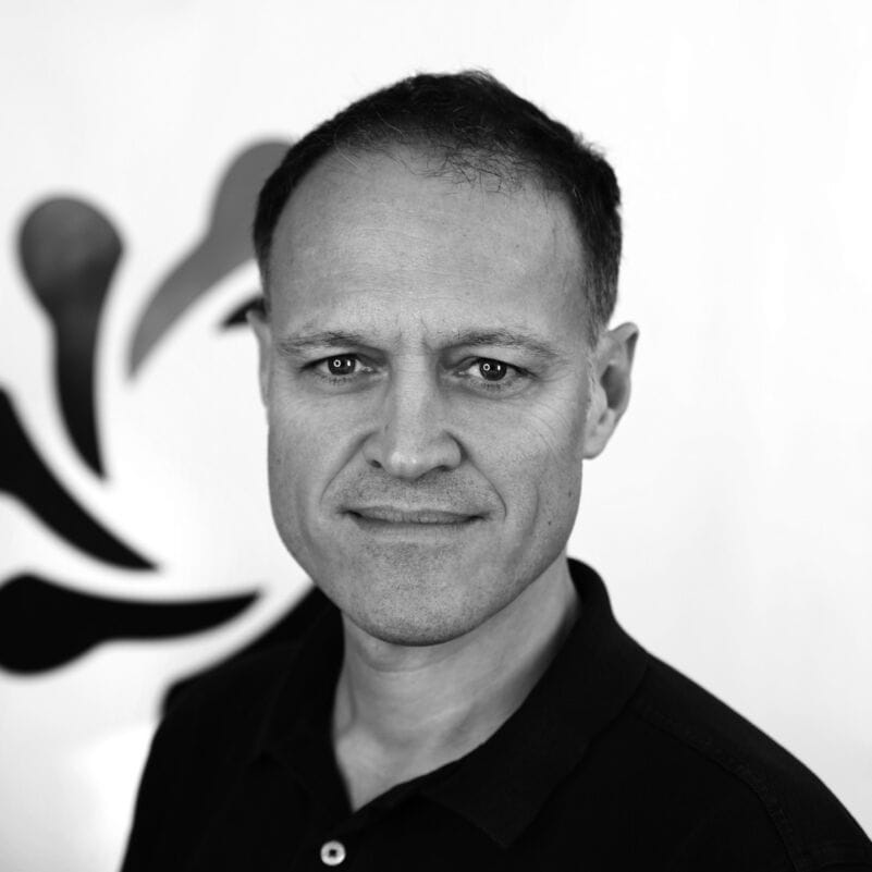 Dominic Monkhouse, business coach based in London, in black and white photo.