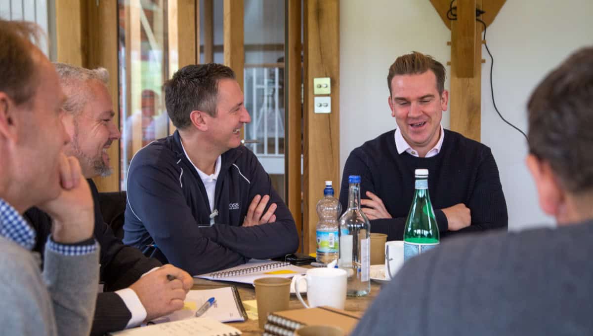 CEO coaching participants discussing scaling constraints during an indoor workshop session