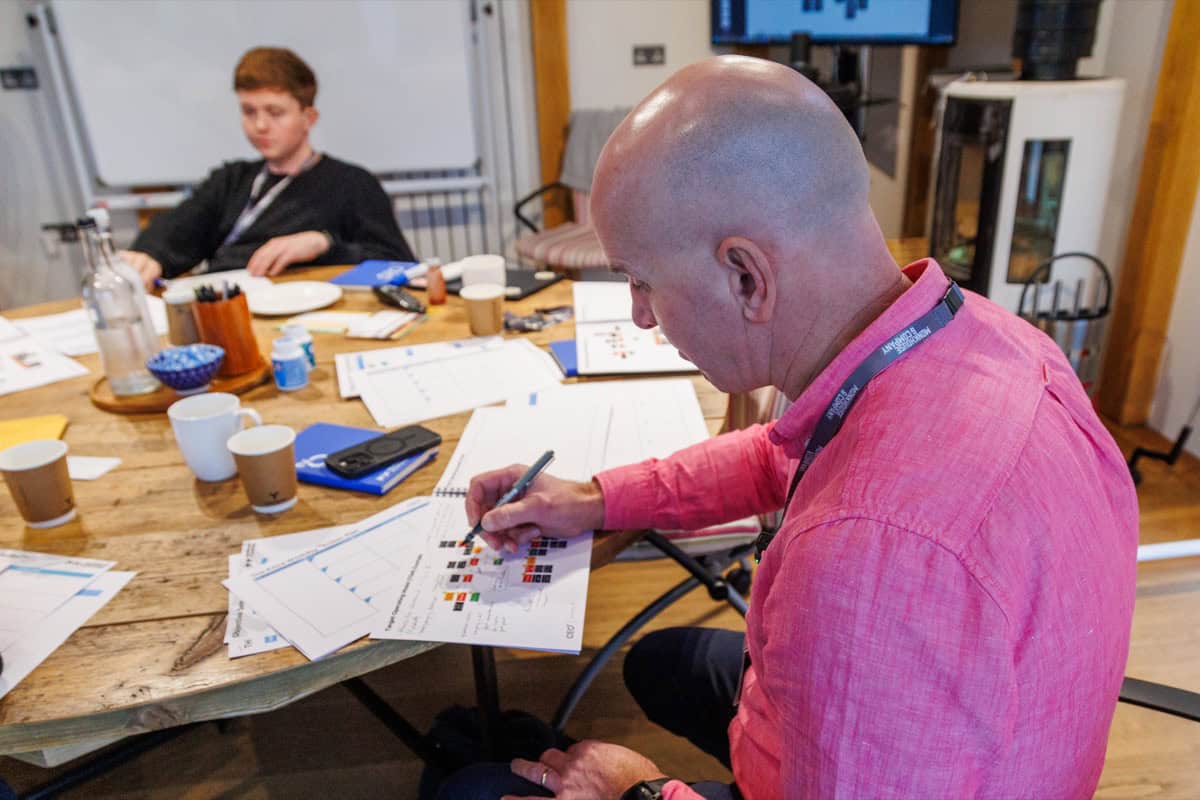 Dominic Monkhouse writing notes during a CEO coaching session with a colleague