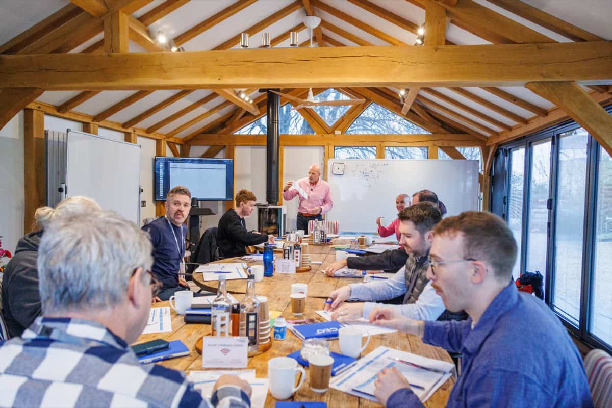 Dominic Monkhouse leading a CEO mentoring session with scaling founder-CEOs around a wooden table at Foundry Farm in 2026.