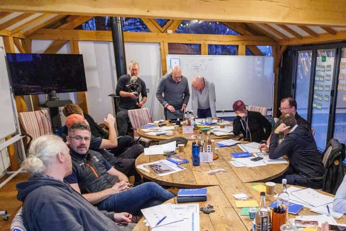 Founder-CEOs in a scaling up business workshop discussing operating decisions around a wooden table