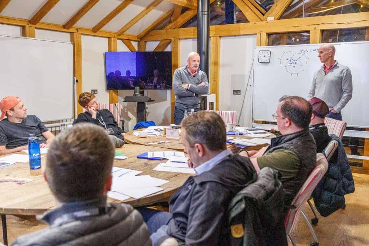 Leadership team in a management meeting workshop around a whiteboard at Monkhouse and Company Farm