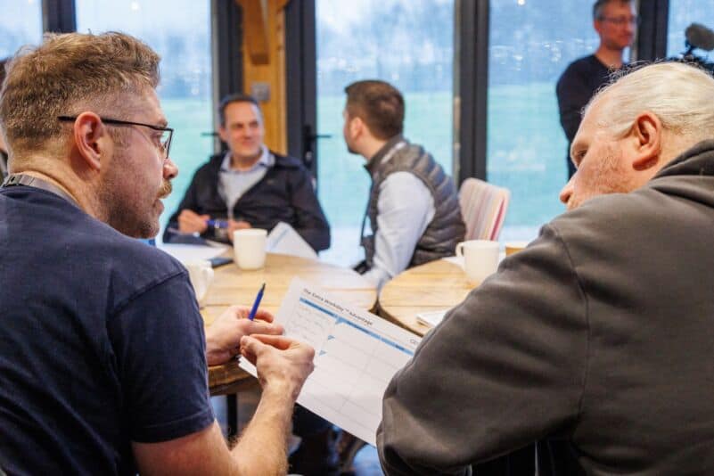 Founders reviewing a sales compensation worksheet together during a coaching workshop