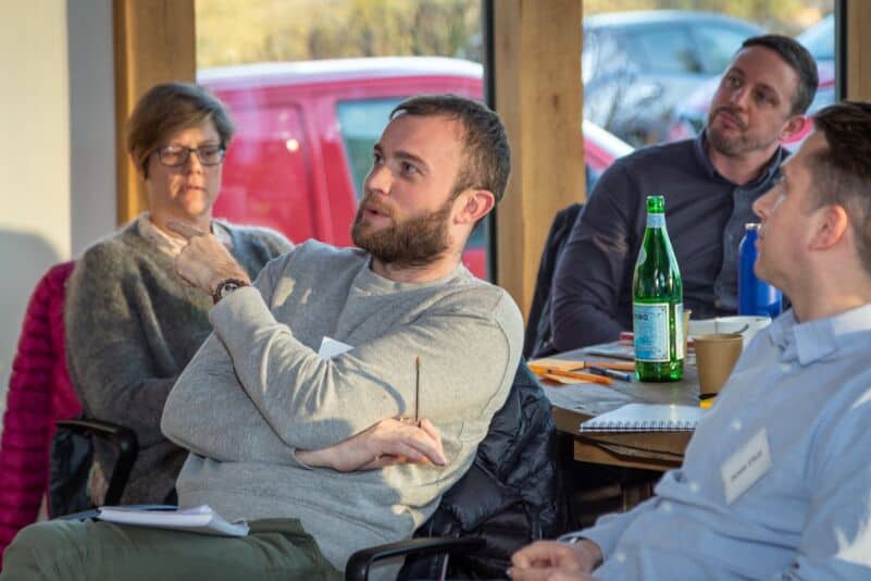 Business meeting at Monkhouse & Company with professionals engaged in discussion.