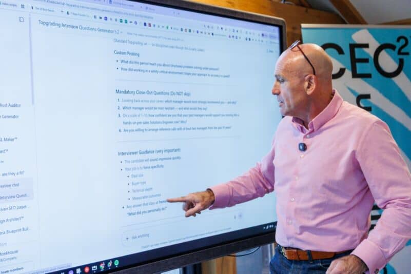 Businessman presenting on a large screen during a Monkhouse & Company workshop.